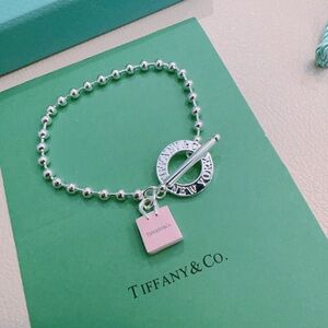 Tiffany & Co. Sterling Silver Bead Bracelet with Pink Tag and Round Logo Charm